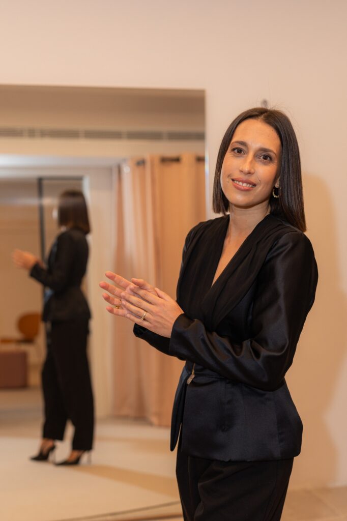 Portriat of Ariane Delarue standing in a black suit smiling