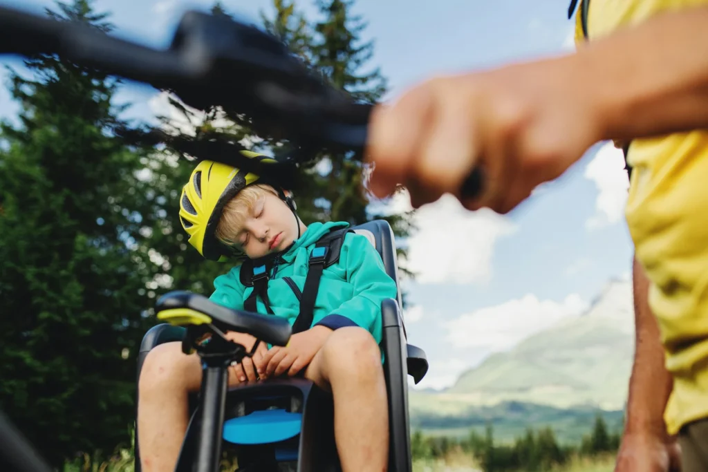 Family on cycling holiday, young boy asleep in chair