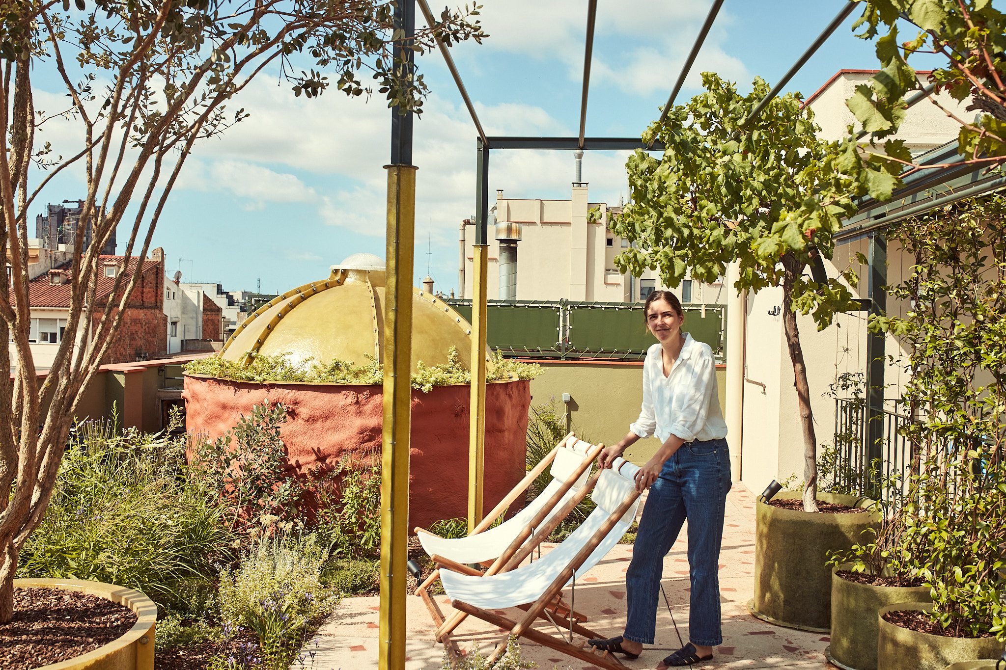 Inés Miró Sans standing beside loungers on the rooftop garden of Termas Bonay, Barcelona.